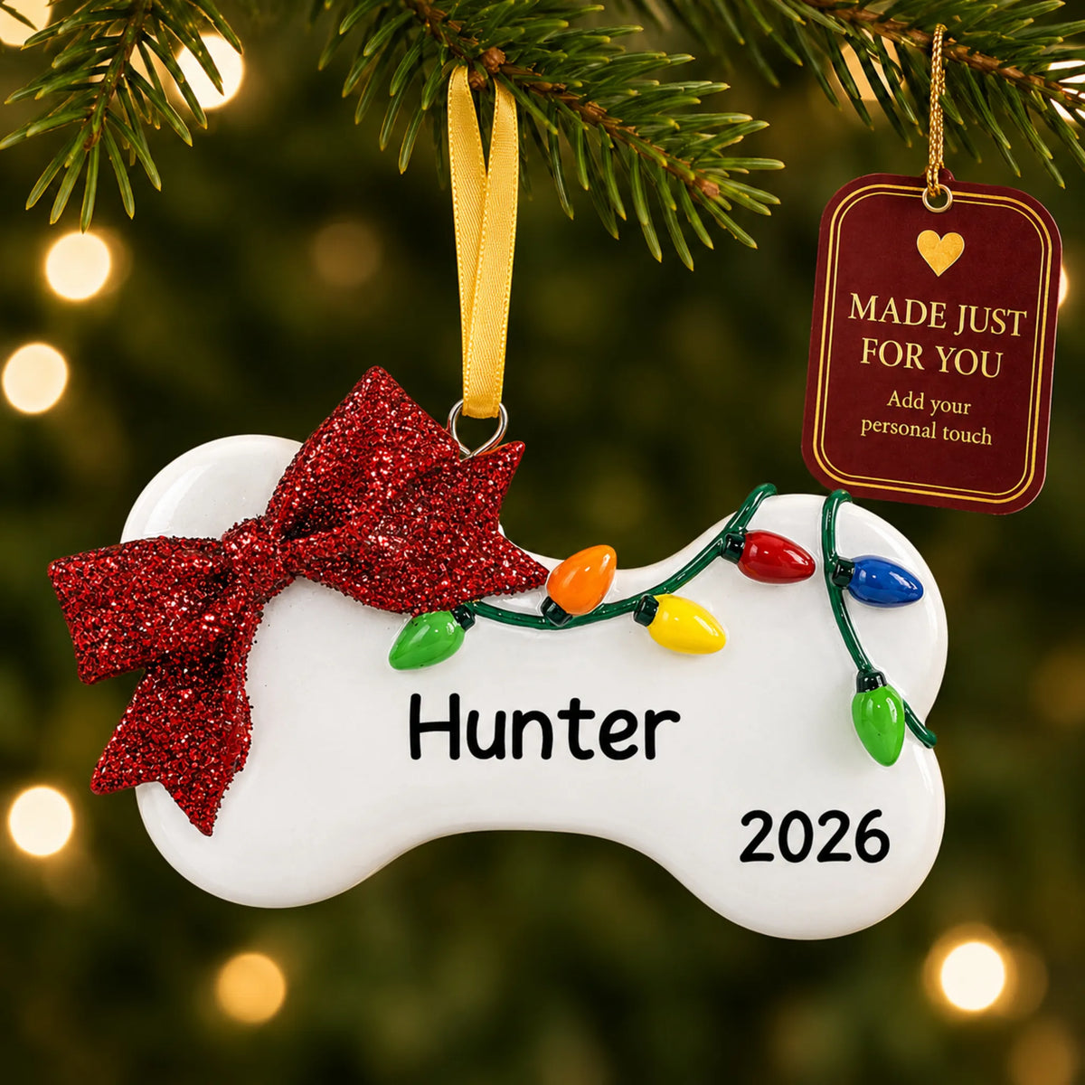 Holiday Lights Dog Bone christmas ornament hanging on a lit Christmas tree with a Made Just For You gift tag