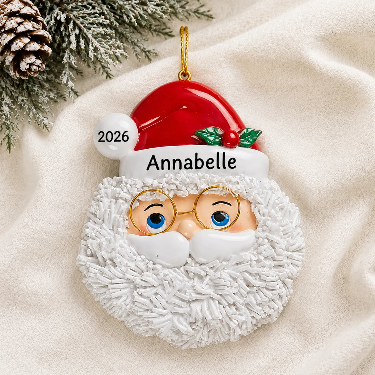 Personalized Santa Claus christmas ornament laid on a soft white knit blanket