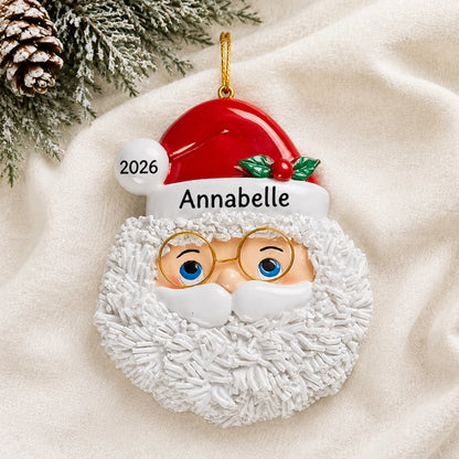 Personalized Santa Claus christmas ornament laid on a soft white knit blanket