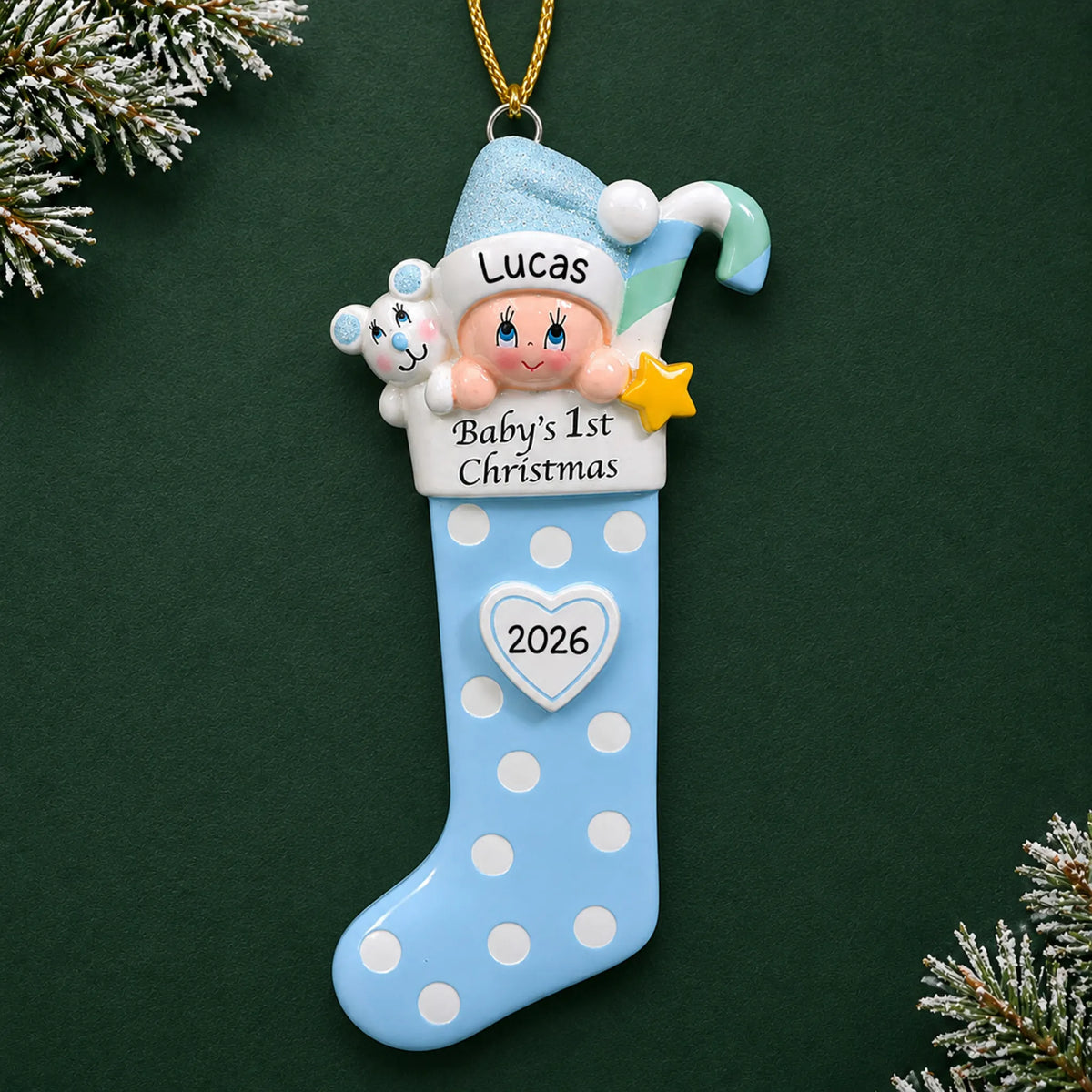 Personalized blue baby's 1st christmas stocking ornament on a dark green pine background