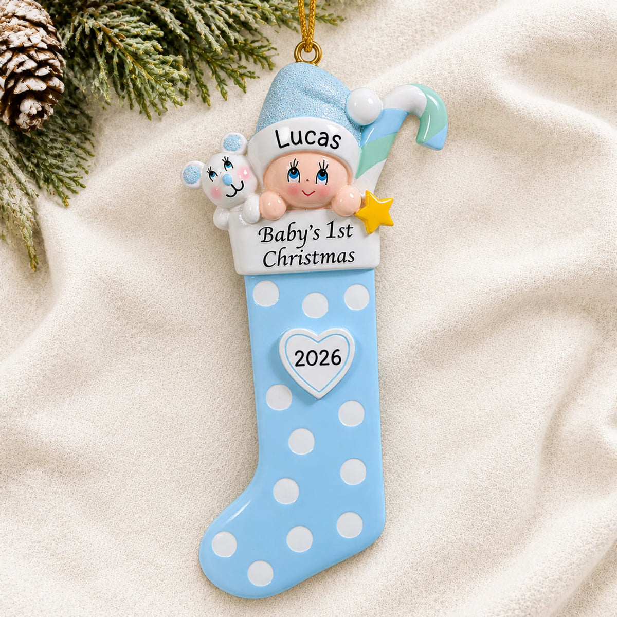 Personalized blue baby's 1st christmas stocking ornament laid on a soft white knit blanket