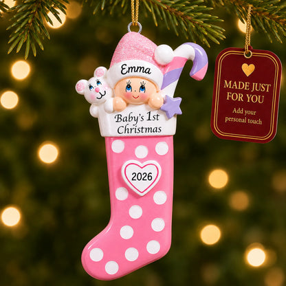 Pink baby's 1st christmas stocking ornament hanging on a lit Christmas tree with a Made Just For You gift tag