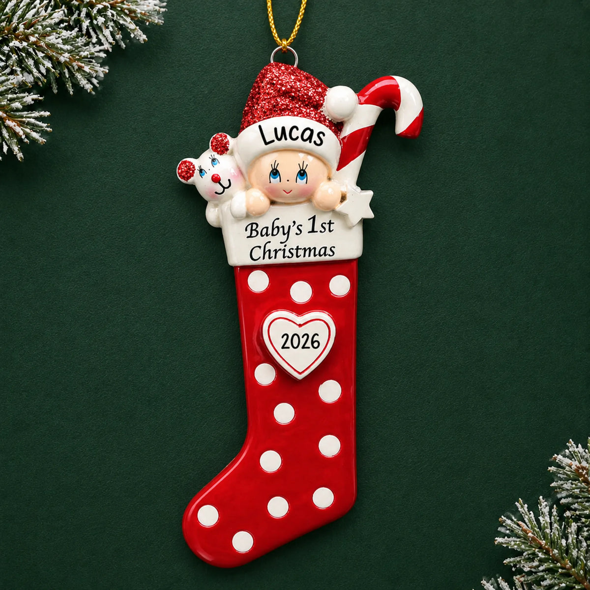 Personalized red baby's 1st christmas stocking ornament on a dark green pine background