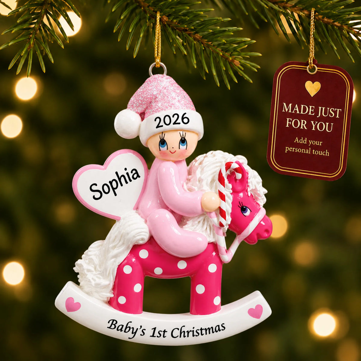 Pink baby's 1st christmas rocking horse ornament hanging on a lit Christmas tree with a Made Just For You gift tag