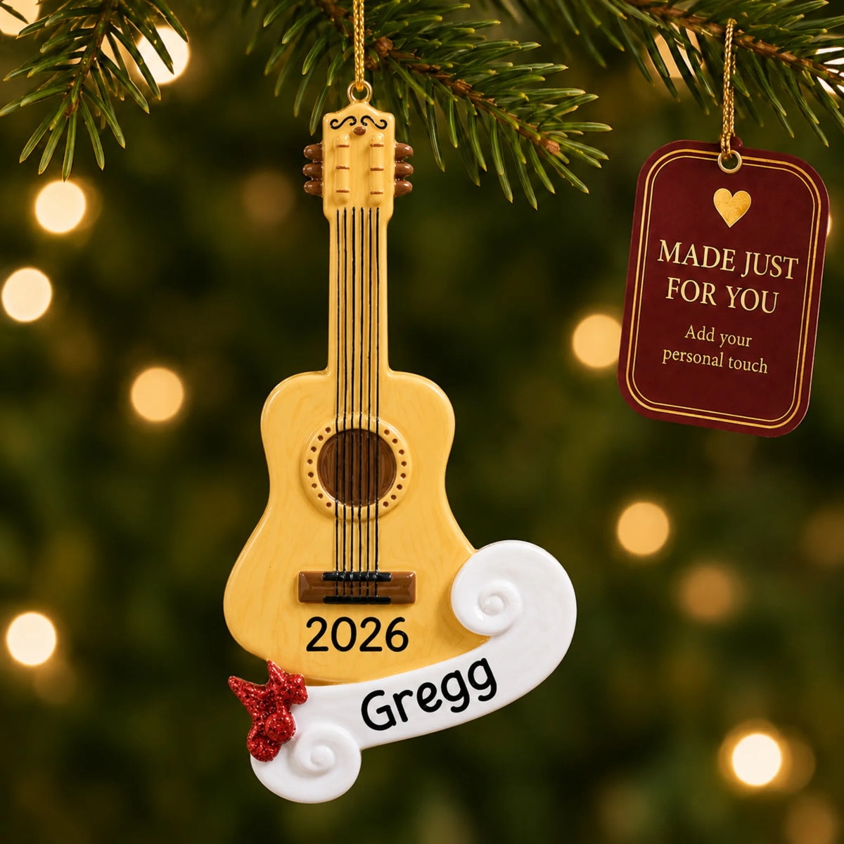 Acoustic guitar christmas ornament hanging on a lit Christmas tree with a Made Just For You gift tag