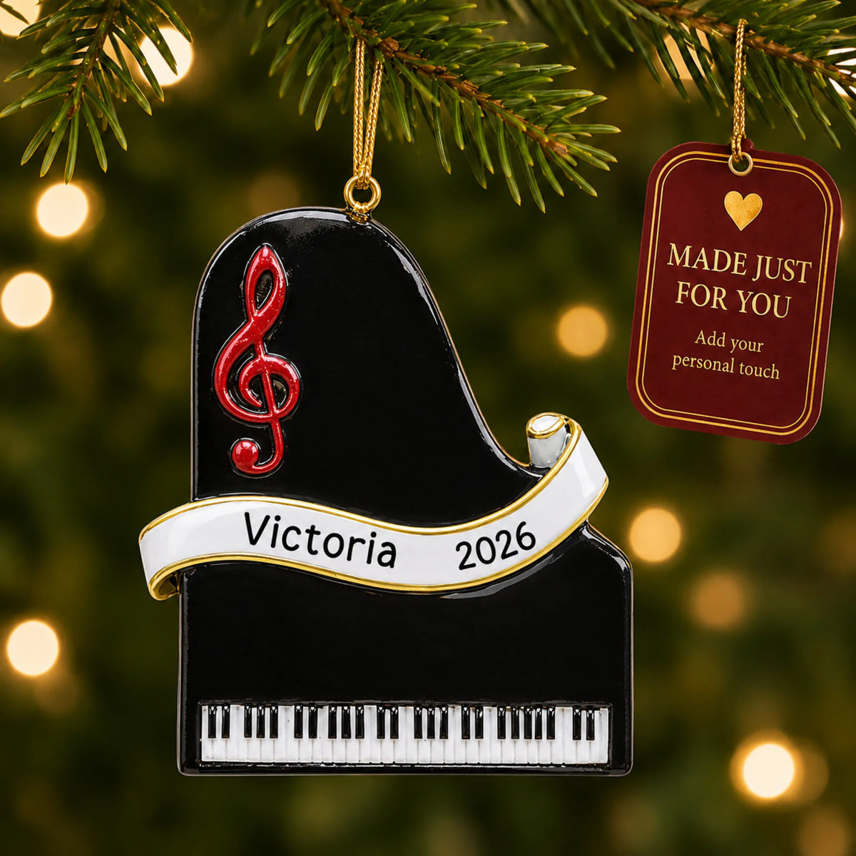 Grand piano christmas ornament hanging on a lit Christmas tree with a Made Just For You gift tag