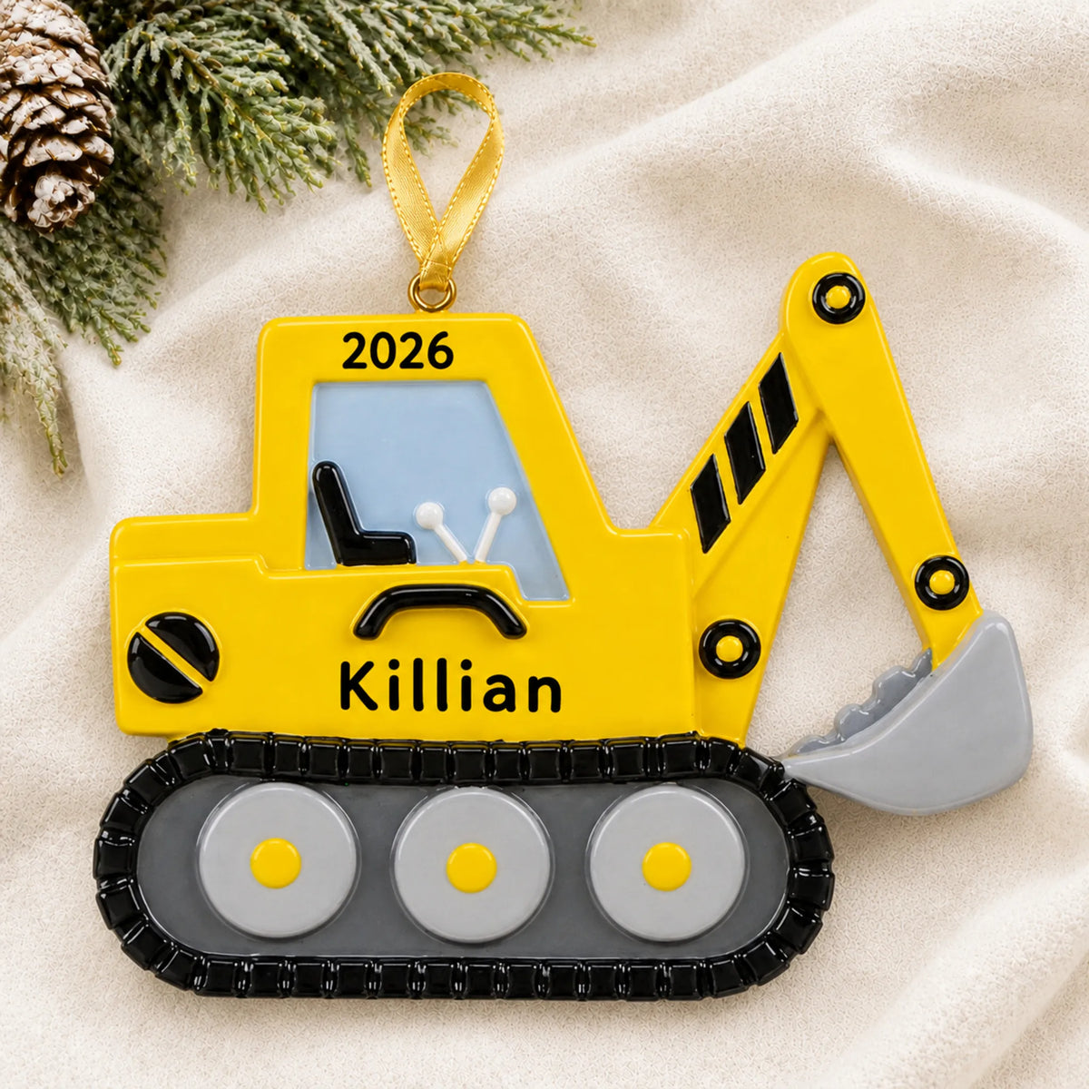 Personalized excavator christmas ornament laid on a soft white knit blanket