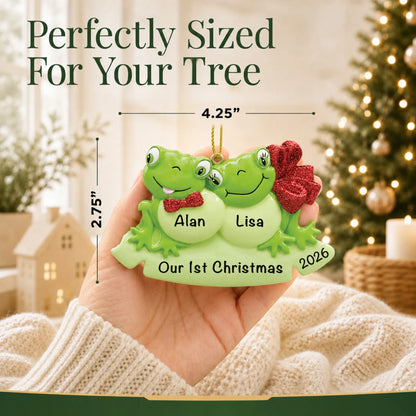 Size guide: the personalized frog couple christmas ornament is 4.25 in wide by 2.75 in tall, shown in hand