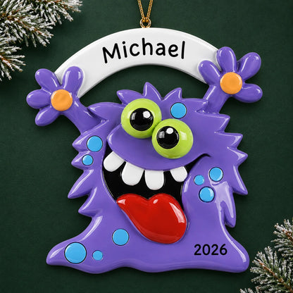 Personalized purple monster christmas ornament on a dark green pine background