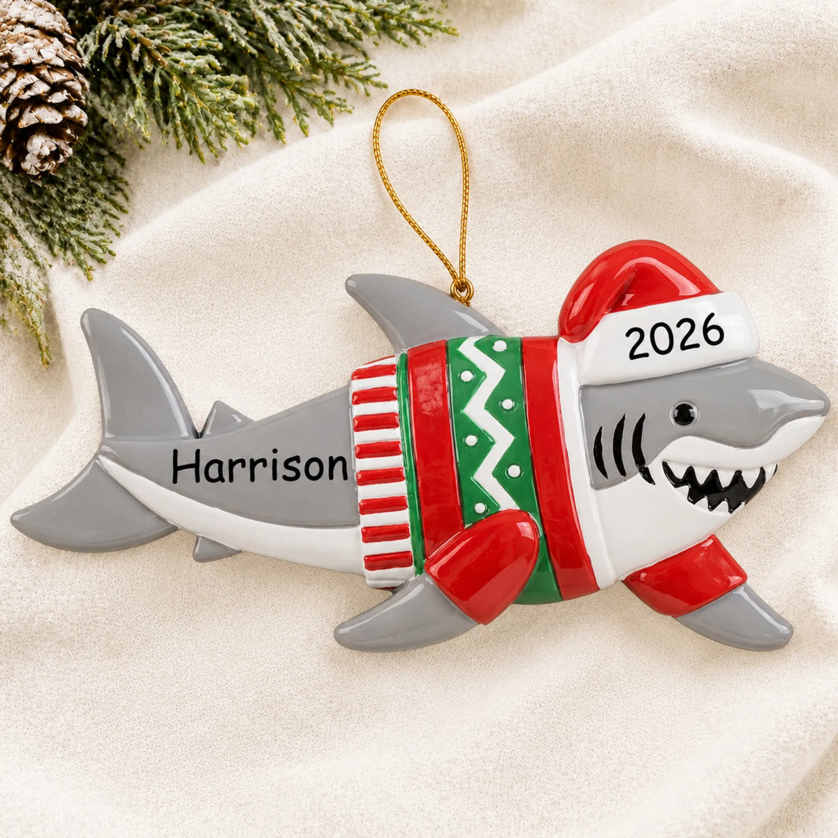 Personalized shark fun christmas ornament laid on a soft white knit blanket