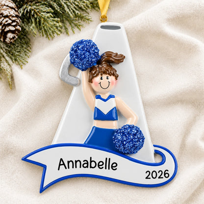 Personalized cheerleader blue megaphone christmas ornament laid on a soft white knit blanket
