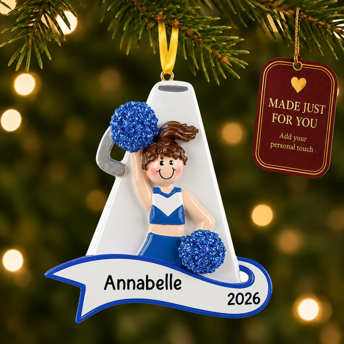 Cheerleader blue megaphone christmas ornament hanging on a lit Christmas tree with a Made Just For You gift tag