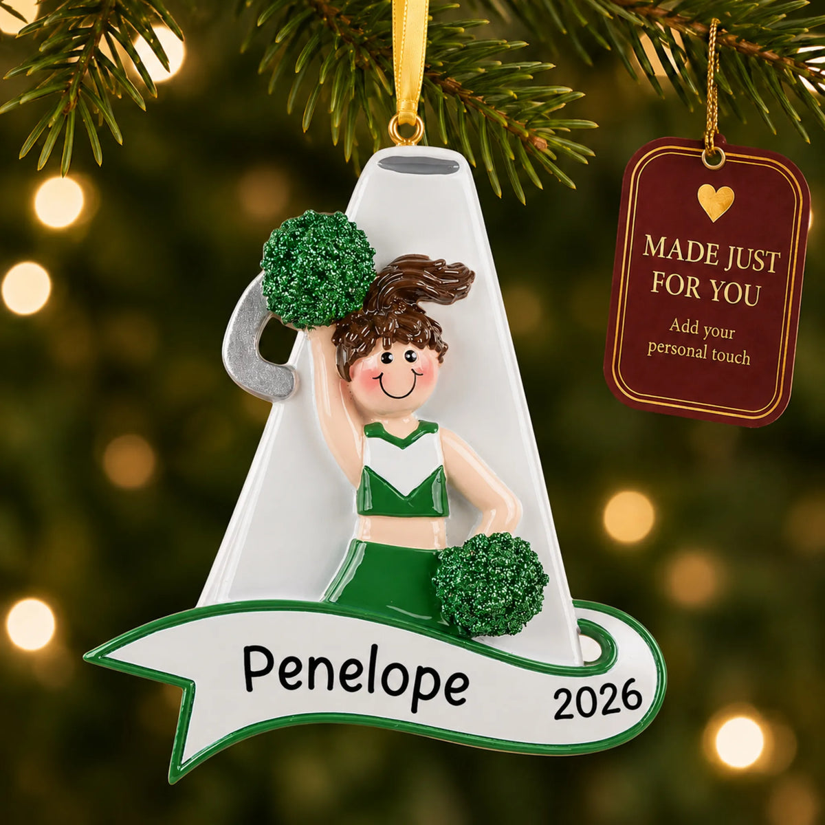 Cheerleader green megaphone christmas ornament hanging on a lit Christmas tree with a Made Just For You gift tag
