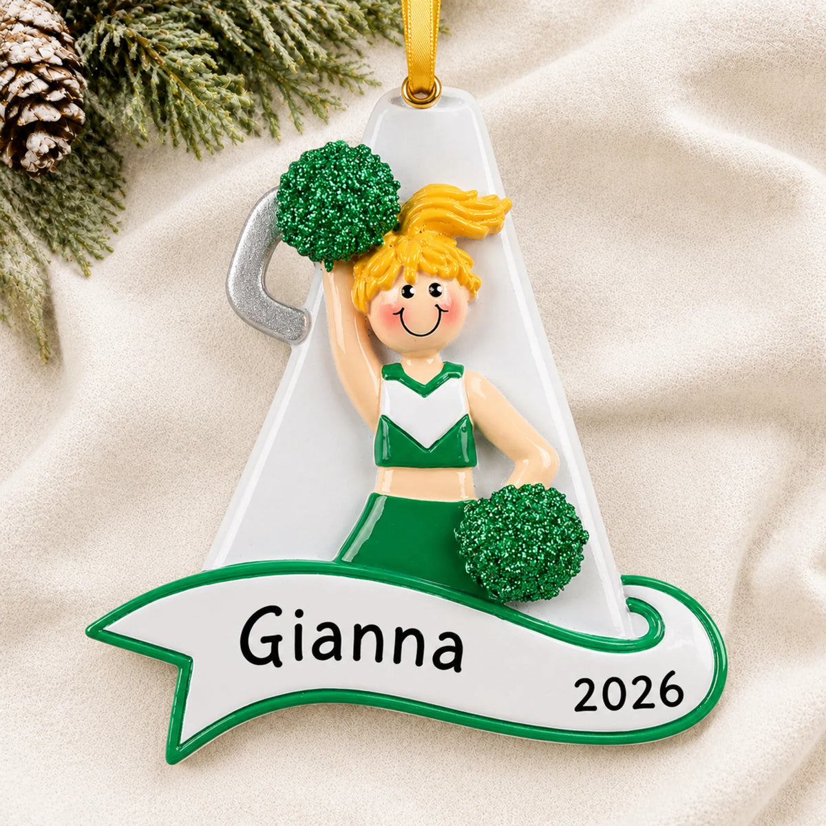 Personalized blonde cheerleader green megaphone christmas ornament laid on a soft white knit blanket