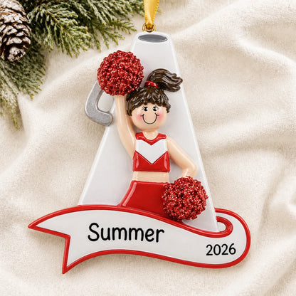 Personalized cheerleader red megaphone christmas ornament laid on a soft white knit blanket