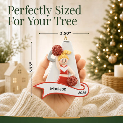 Size guide: the personalized blonde cheerleader red megaphone christmas ornament shown in hand next to a Christmas tree