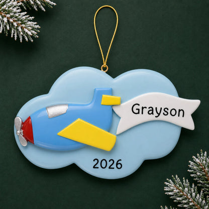 Personalized airplane christmas ornament on a dark green pine background