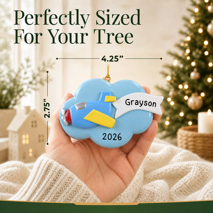 Size guide: the personalized airplane christmas ornament is 4.25 in wide by 2.75 in tall, shown in hand