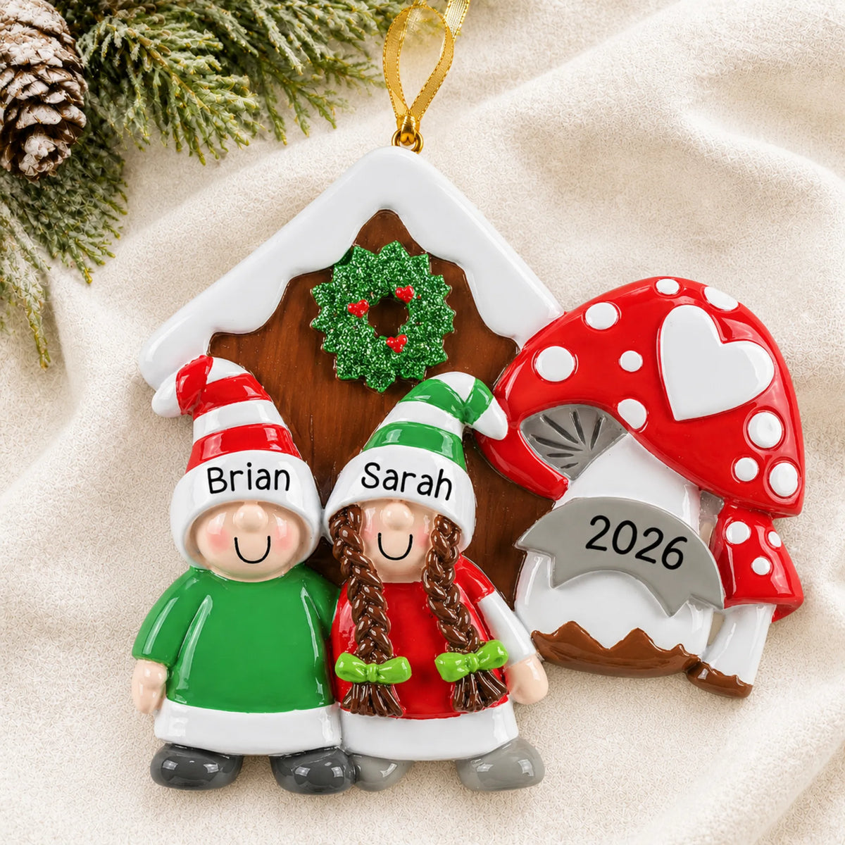 Personalized gnome mushroom couple christmas ornament laid on a soft white knit blanket