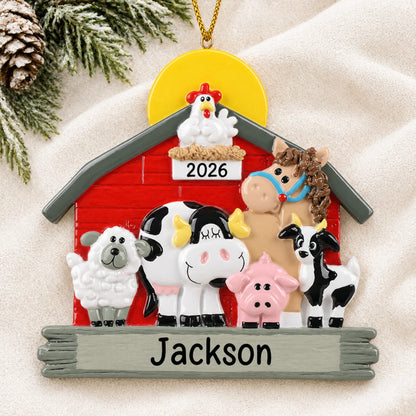 Personalized farm animals barn christmas ornament laid on a soft white knit blanket