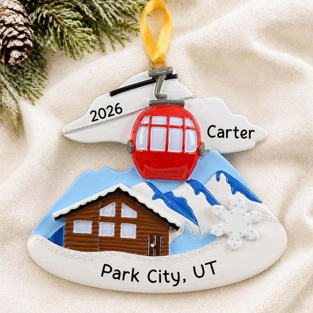 Personalized ski lodge christmas ornament laid on a soft white knit blanket
