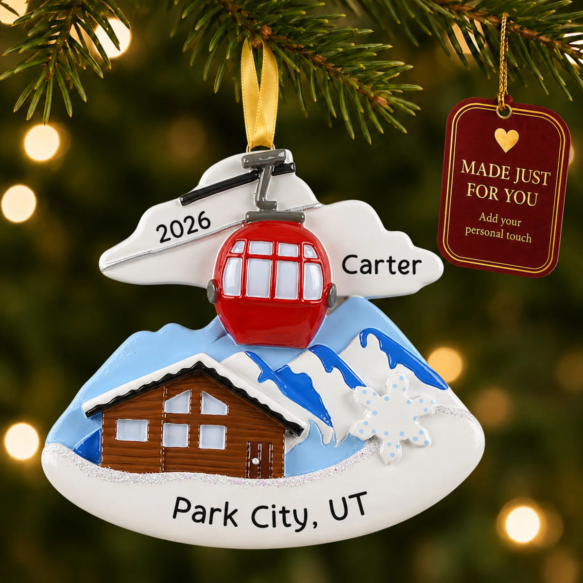 Ski lodge christmas ornament hanging on a lit Christmas tree with a Made Just For You gift tag