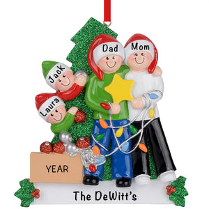 Personalized family of 4 decorating the Christmas tree ornament with names on Santa hats