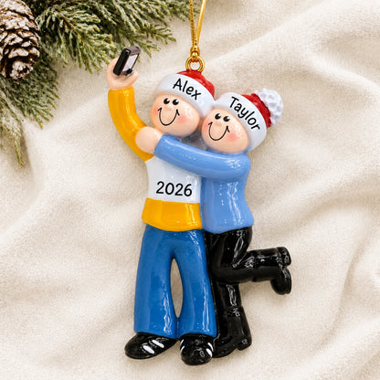 Personalized selfie couple christmas ornament laid on a soft white knit blanket