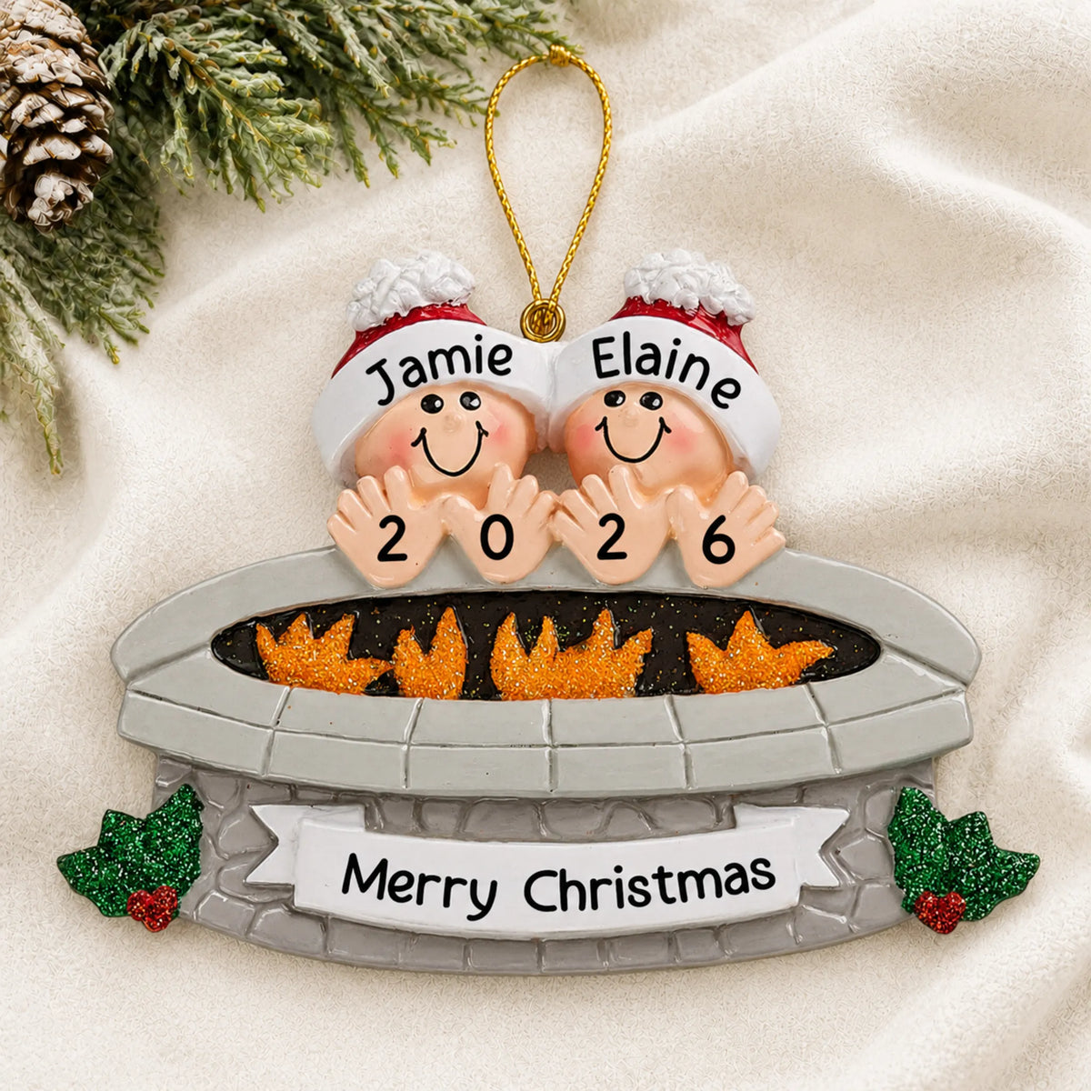Personalized fire pit couple christmas ornament laid on a soft white knit blanket