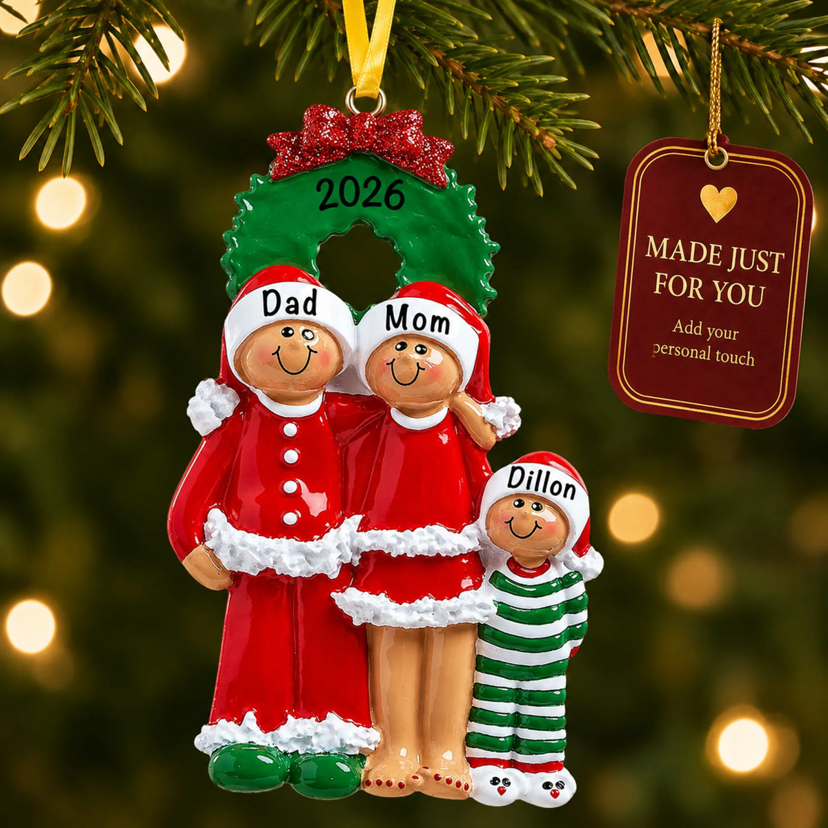 Ethnic family of 3 christmas ornament hanging on a lit Christmas tree with a Made Just For You gift tag
