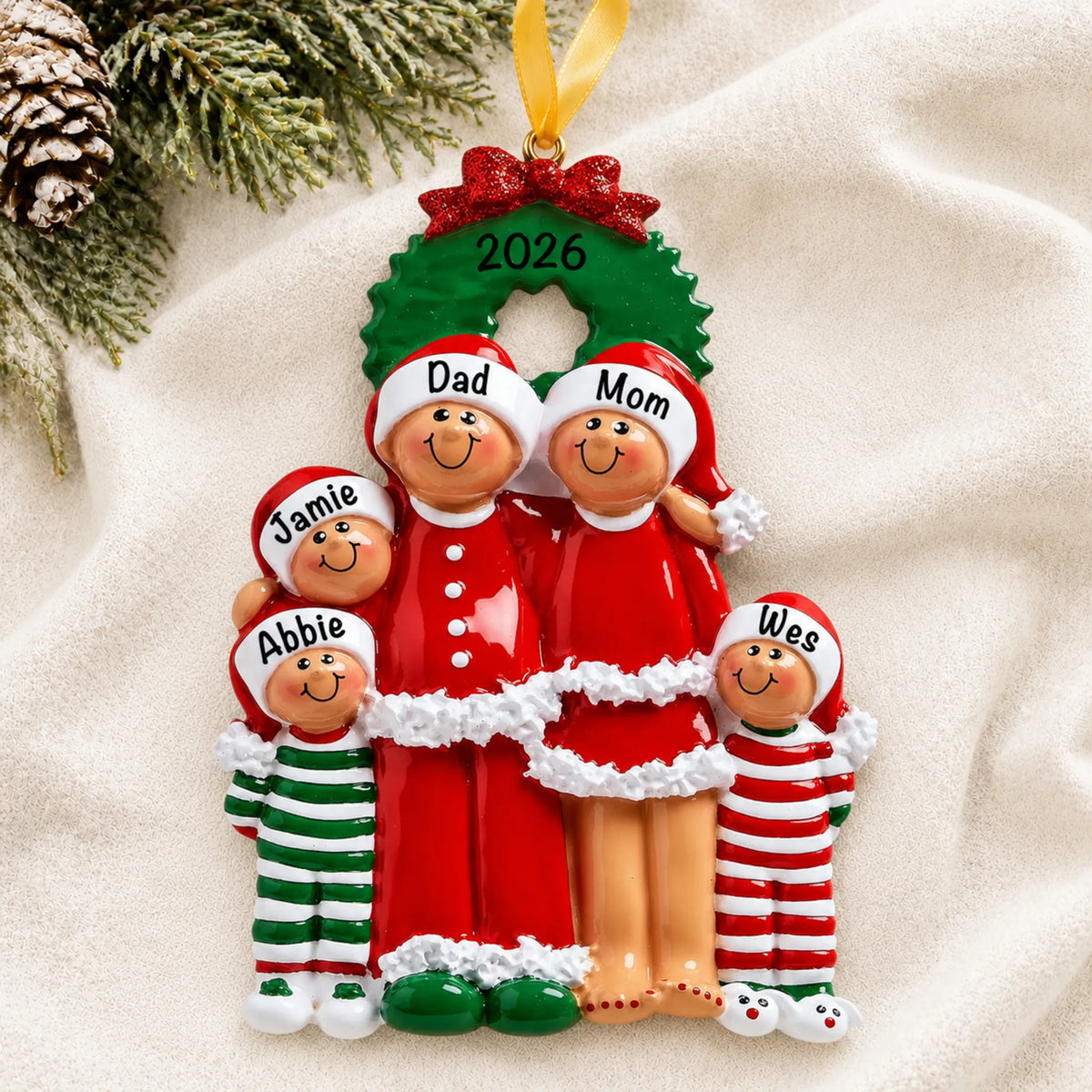 Personalized ethnic family of 5 christmas ornament laid on a soft white knit blanket