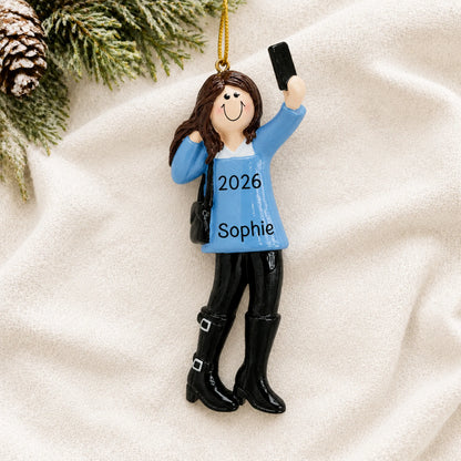 Personalized selfie girl christmas ornament laid on a soft white knit blanket