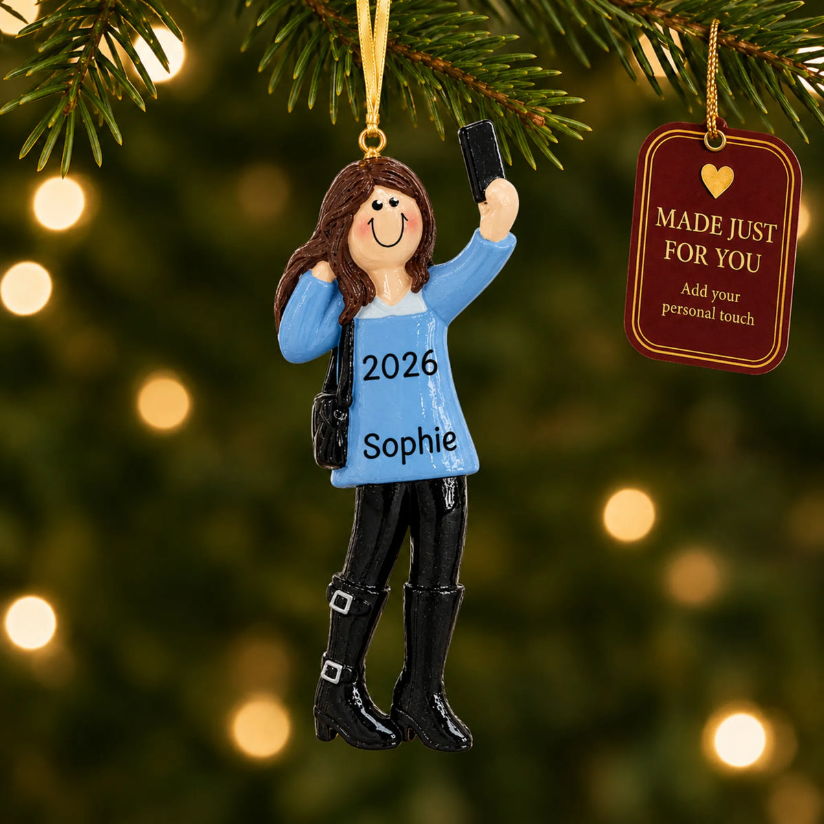 Selfie girl christmas ornament hanging on a lit Christmas tree with a Made Just For You gift tag