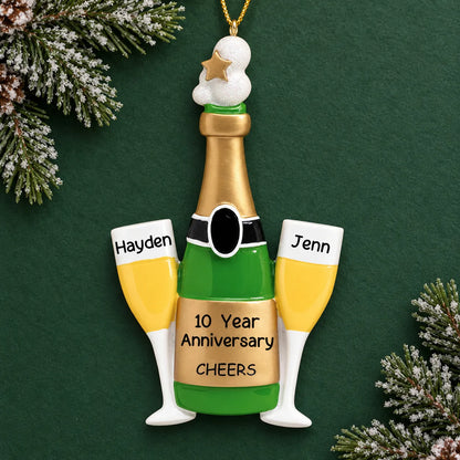 Personalized champagne anniversary Christmas ornament reading Hayden, Jenn, and 10 Year Anniversary on dark green