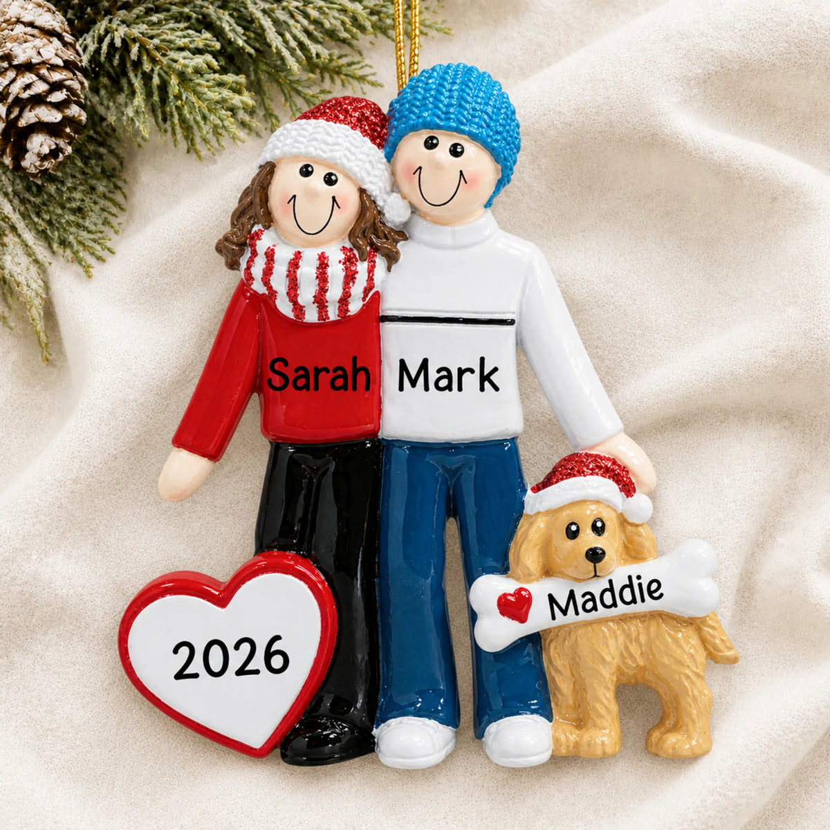 Personalized winter couple with dog christmas ornament laid on a soft white knit blanket