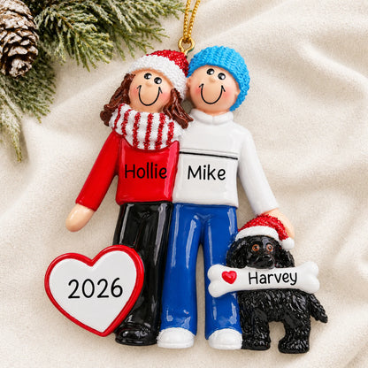 Personalized winter couple with black dog christmas ornament laid on a soft white knit blanket