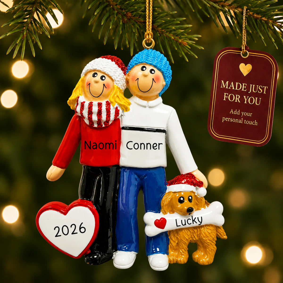 Blonde couple with dog christmas ornament hanging on a lit Christmas tree with a Made Just For You gift tag