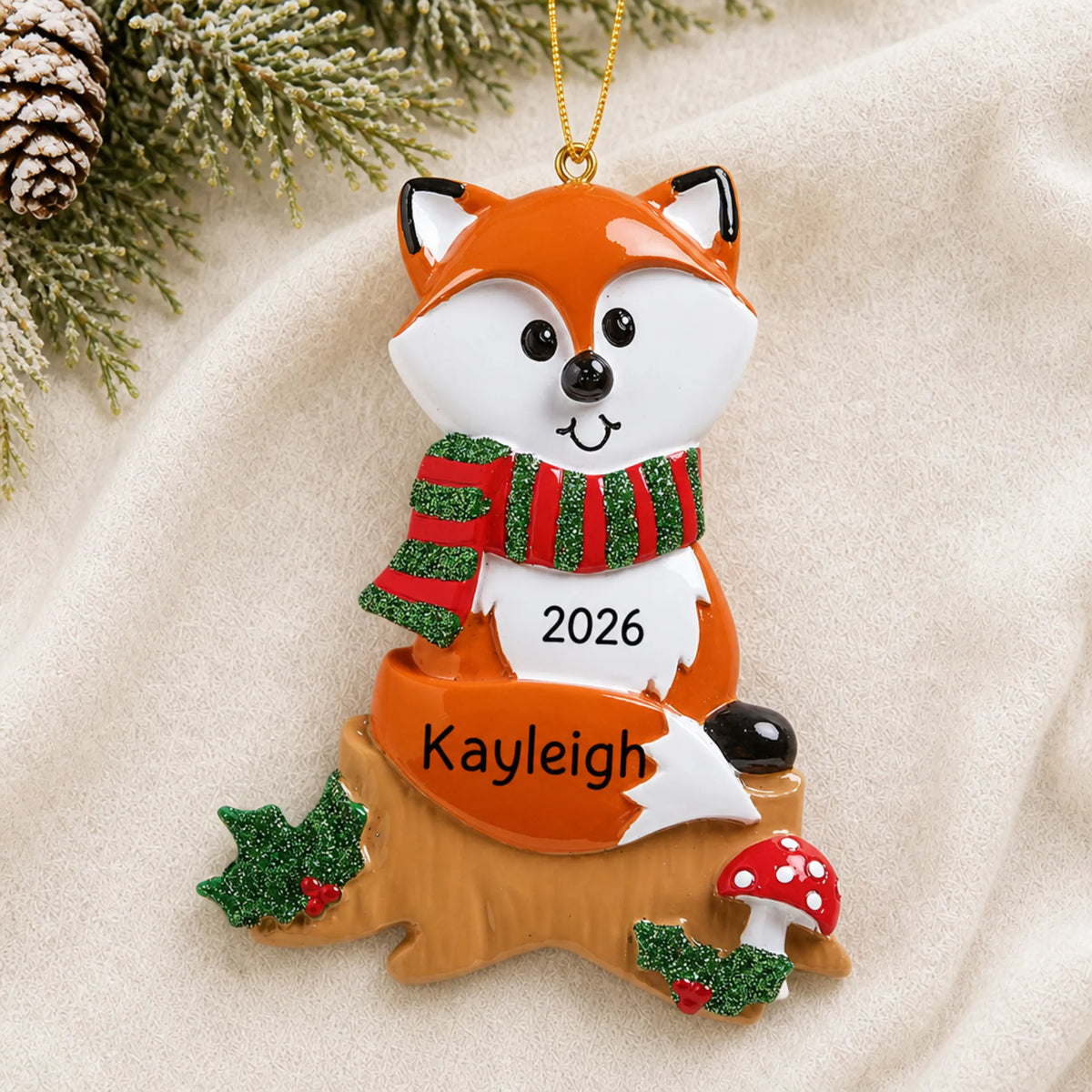 Personalized fox christmas ornament laid on a soft white knit blanket