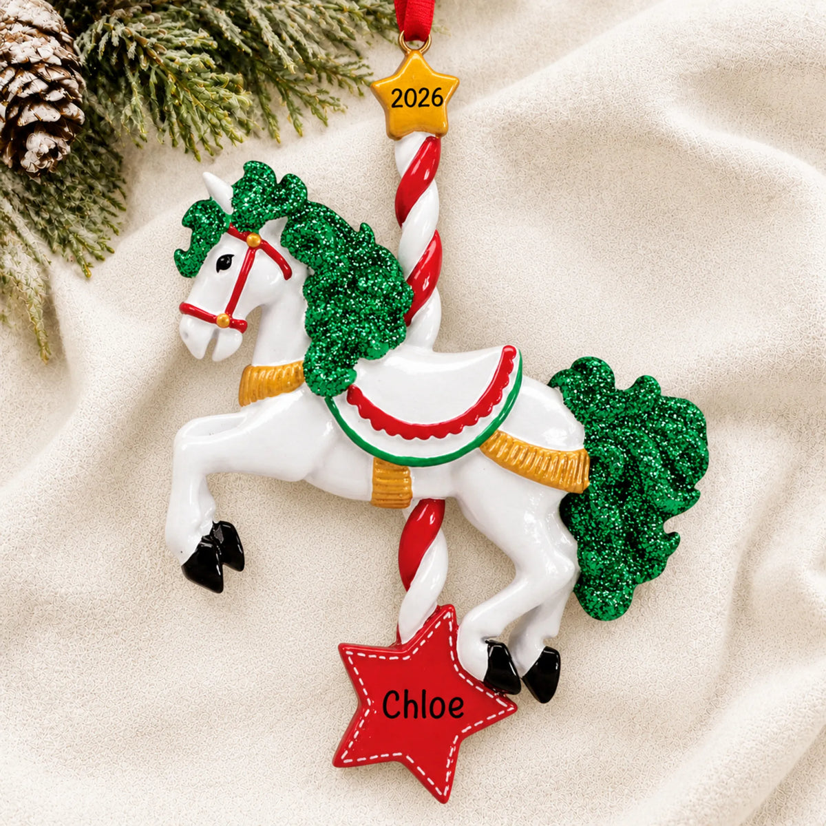 Personalized carousel horse christmas ornament laid on a soft white knit blanket