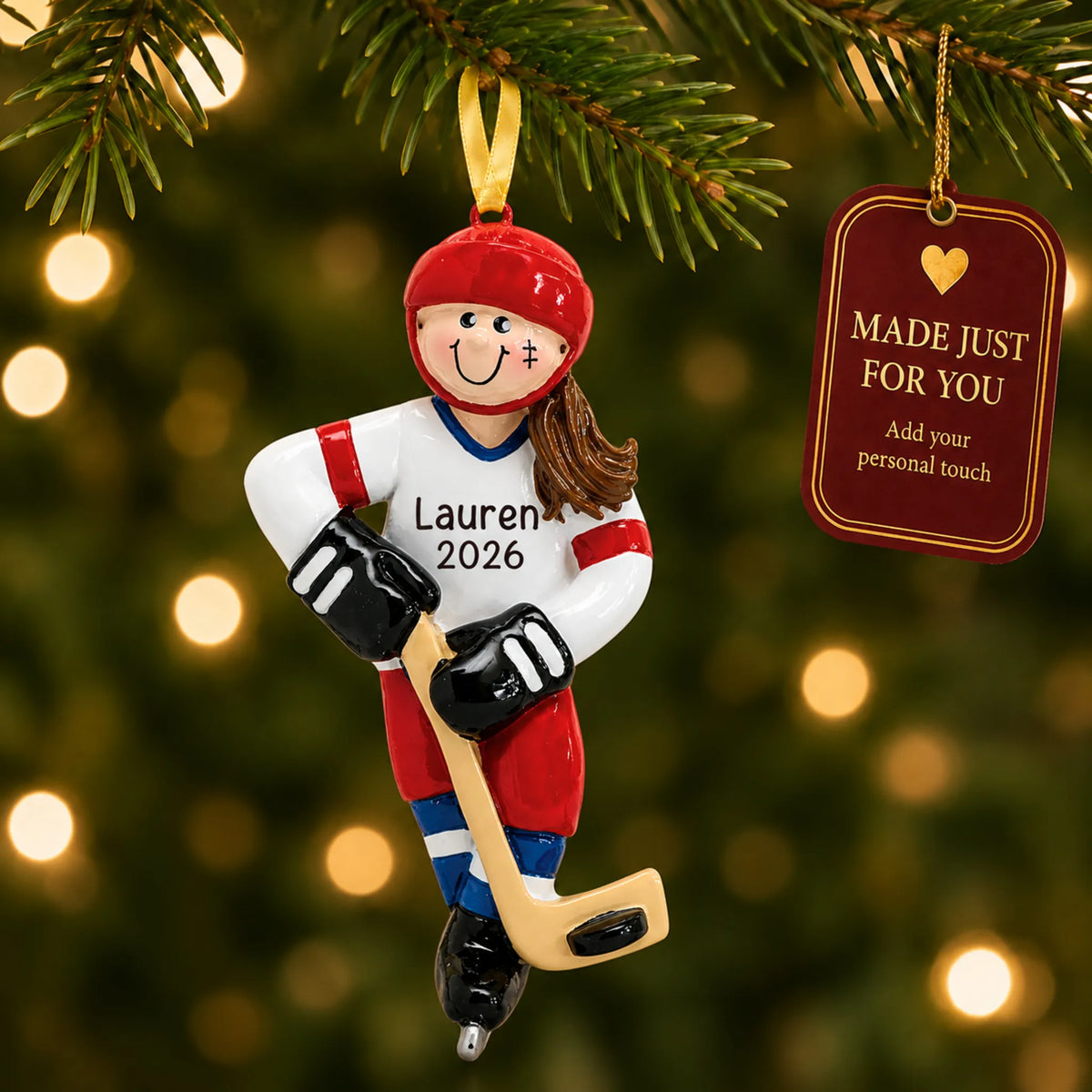 Ice hockey girl christmas ornament hanging on a lit Christmas tree with a Made Just For You gift tag