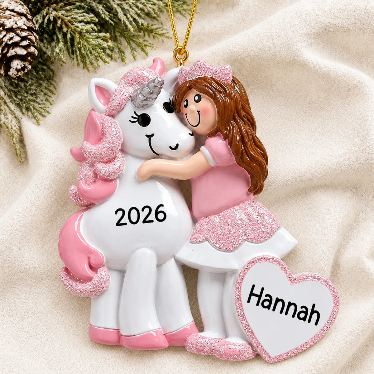 Personalized princess & unicorn christmas ornament laid on a soft white knit blanket