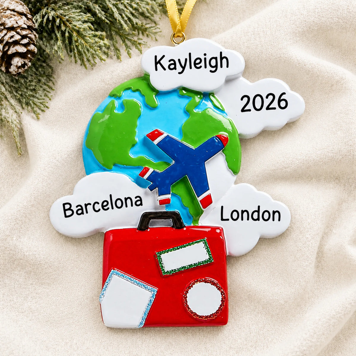 Personalized world traveler christmas ornament laid on a soft white knit blanket