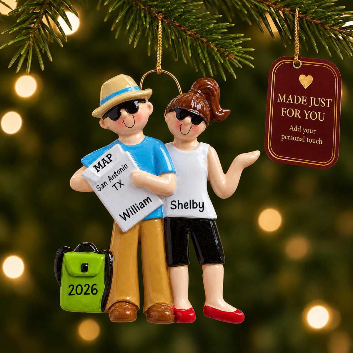 Travel couple christmas ornament hanging on a lit Christmas tree with a Made Just For You gift tag