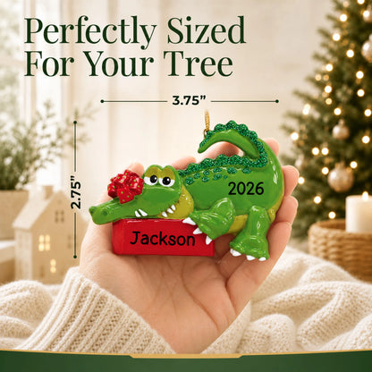 Size guide: the personalized alligator christmas ornament is 3.75 in wide by 2.75 in tall, shown in hand