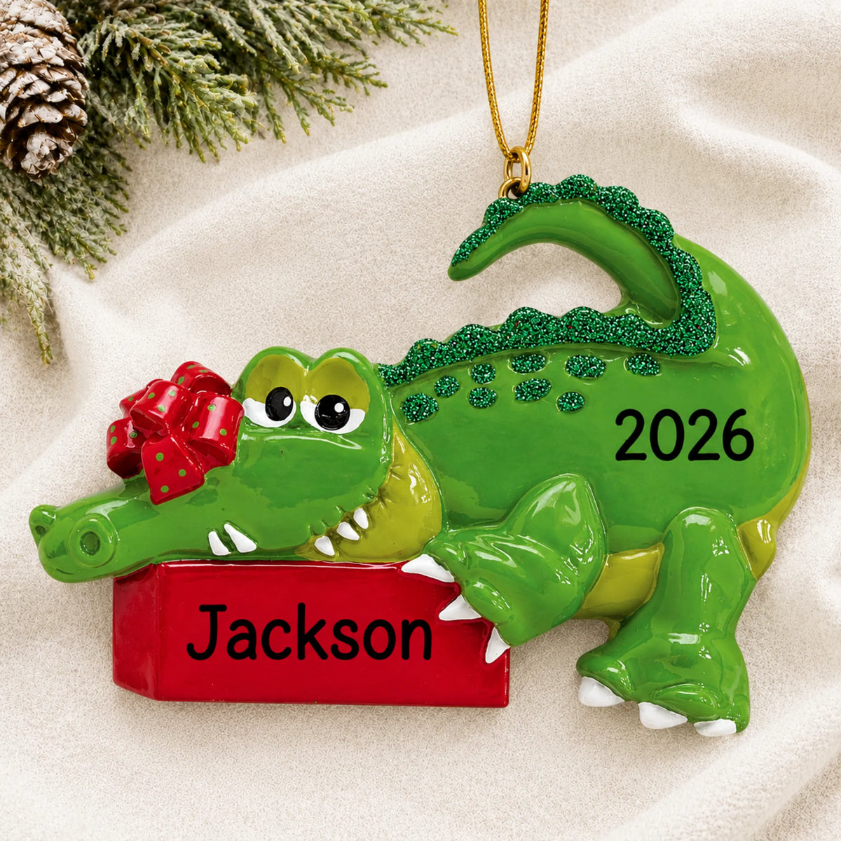 Personalized alligator christmas ornament laid on a soft white knit blanket