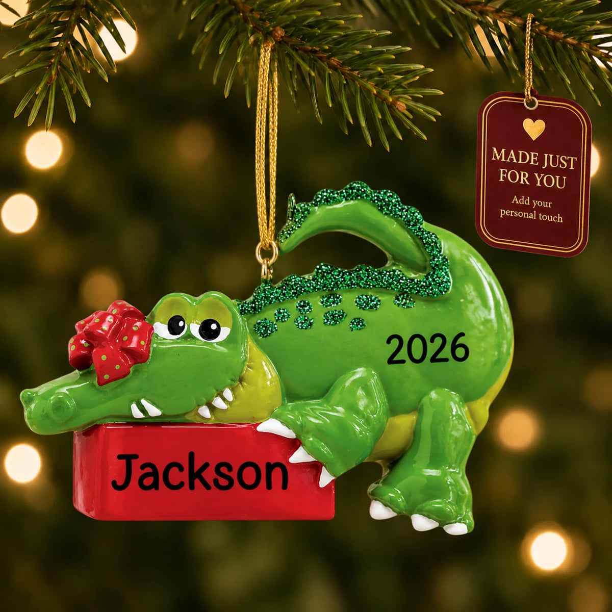 Alligator christmas ornament hanging on a lit Christmas tree with a Made Just For You gift tag