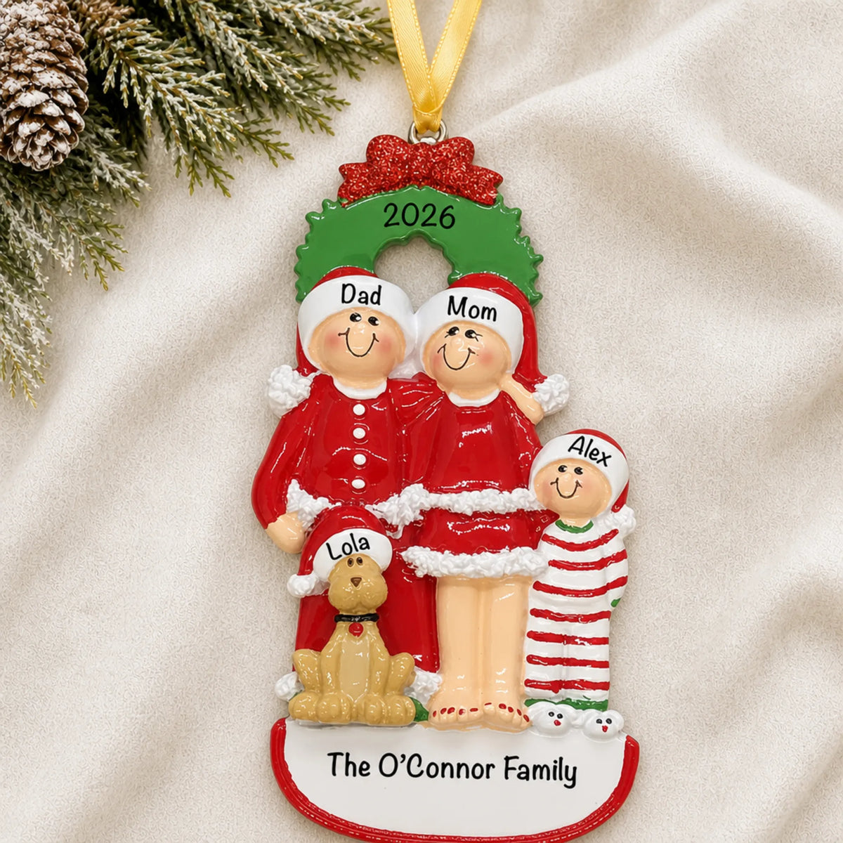 Personalized family of 3 with dog christmas ornament laid on a soft white knit blanket