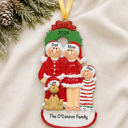 Personalized family of 3 with dog christmas ornament laid on a soft white knit blanket