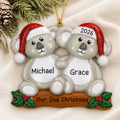 Personalized koala couple christmas ornament laid on a soft white knit blanket