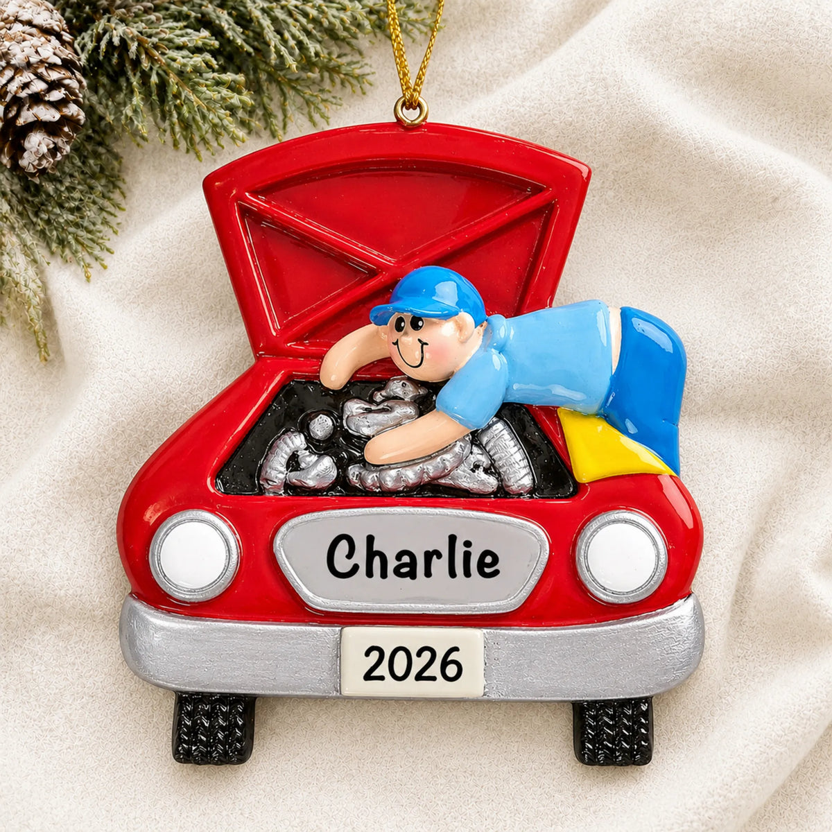 Personalized mechanic christmas ornament laid on a soft white knit blanket